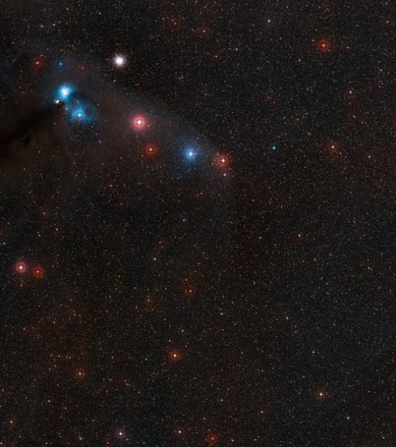 This wide field image shows the sky around the very faint neutron star RX J1856.5-3754 in the southern constellation of Corona Australis. This part of the sky also contains interesting regions of dark and bright nebulosity surrounding the variable star R Coronae Australis (upper left), as well as the globular star cluster NGC 6723. The neutron star itself is too faint to be seen here, but lies very close to the centre of the image.